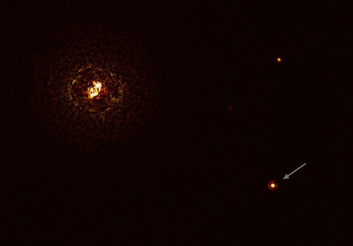 Två små ljuspunkter i omloppsbana runt en central maskerad stjärna